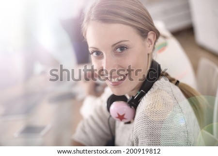 Blond girl in class with music headphones on