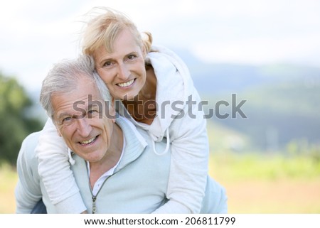 Senior man giving piggyback ride to woman