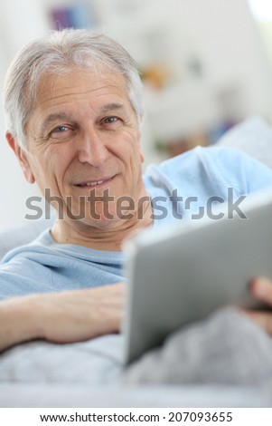 Portrait of senior man using digital tablet