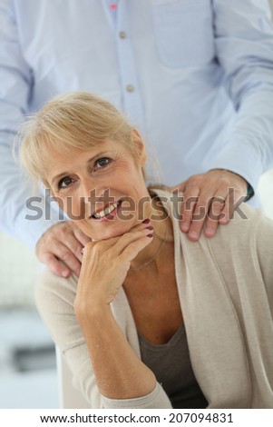 Portrait of senior woman with husband\'s hand on shoulders
