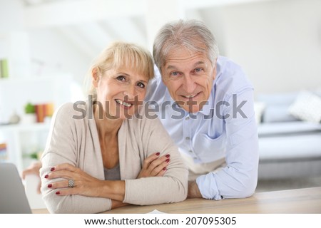 Senior couple at home filling pension paper