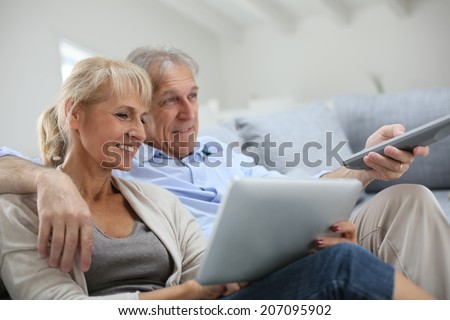 Senior couple sitting in sofa and watching tv