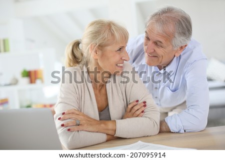 Senior couple at home filling pension paper