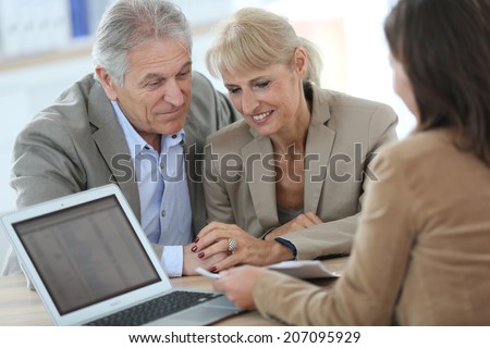 Senior couple meeting financial adviser in office