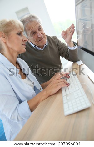 Senior people in office working on desktop computer