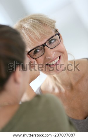Senior woman trying new eyeglasses in optical store