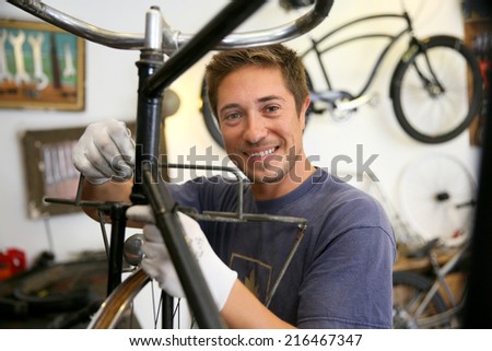 Man in workshop fixing bike frame