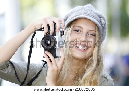 Trendy girl taking pictures with vintage camera