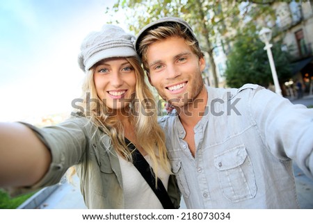 Cheerful trendy couple taking self-portrait picture