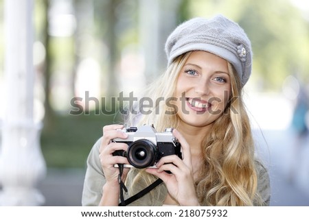 Trendy girl taking pictures with vintage camera