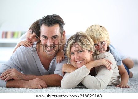Portrait of happy family laying on carpet