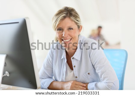 Mature businesswoman sitting in front of desktop