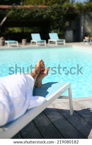 Closeup of woman\'s feet relaxing in long chair