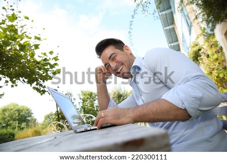 Mature man on week-end working from home with laptop