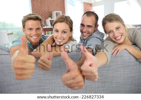 Cheerful roommates showing thumbs up