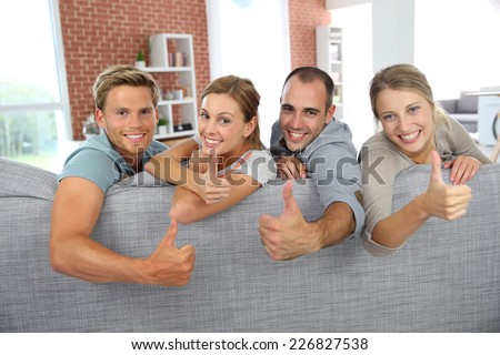 Cheerful roommates showing thumbs up