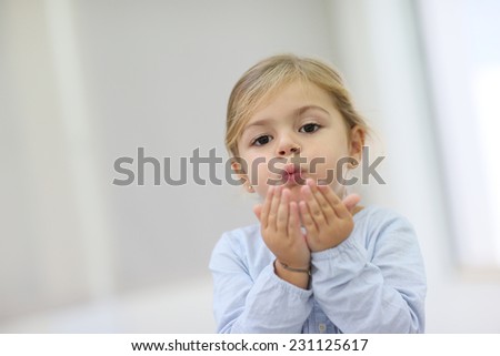 Cute little girl blowing kisses away