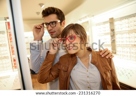 Couple in optical shop choosing eyeglasses