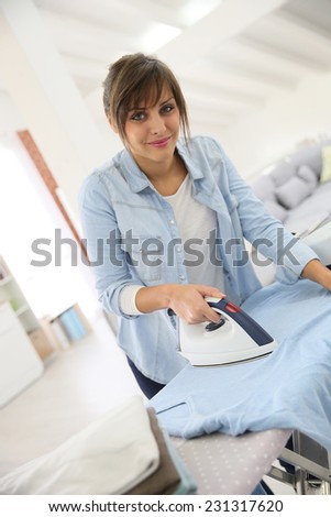 Young home service woman ironing laundry