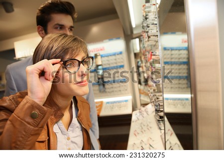 Young couple in optical shop trying eyeglasses
