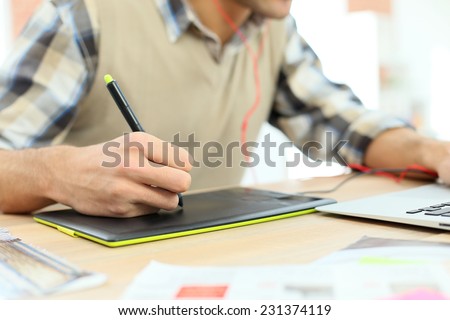 Closeup on designer using graphic tablet for photo editing