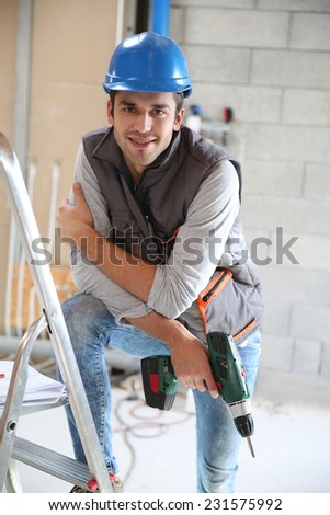 Construction worker holding electric drill