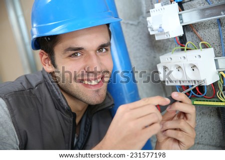 Young electrician working on building site