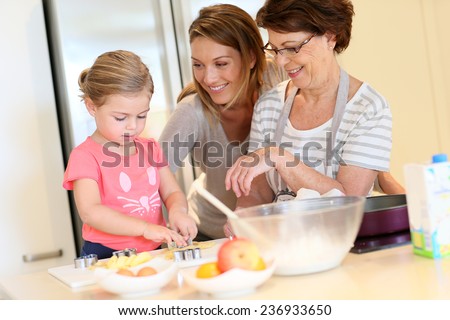 Little girl with mom and grandmother baking cookies at home