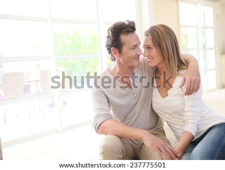 Romantic middle-aged couple sitting on couch