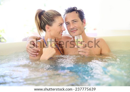Romantic couple drinking cahmpagne in hot tub