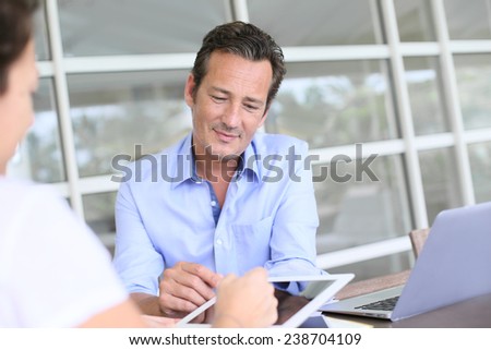 Closeup of businessman having client signing contract on tablet