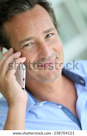 Portrait of 40-year-old man talking on cellphone