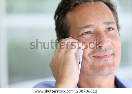 Portrait of 40-year-old man talking on cellphone