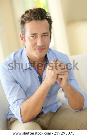 Portrait of single middle-aged man sitting in sofa