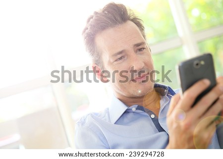 Portrait of middle-aged man using smartphone
