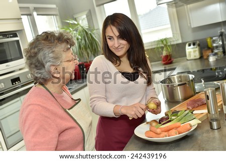 Homecare cooking dinner for elderly woman