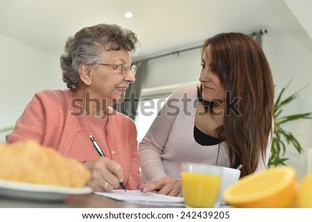 Young woman visiting elderly woman in nursing home