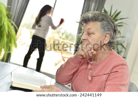 Elderly woman in nursing home reading book