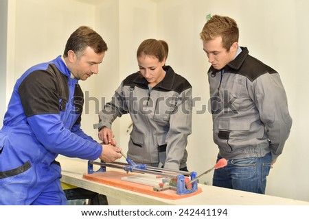 Teacher with students using ceramic saw