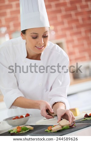 Young chef preparing plate of foie gras