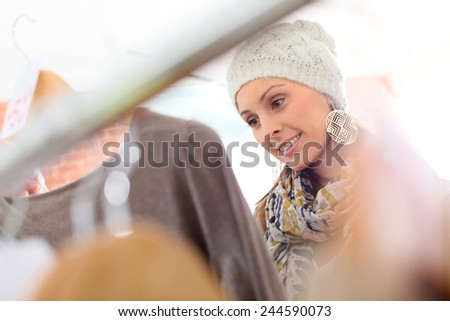 Beautiful woman in store choosing clothes on sale