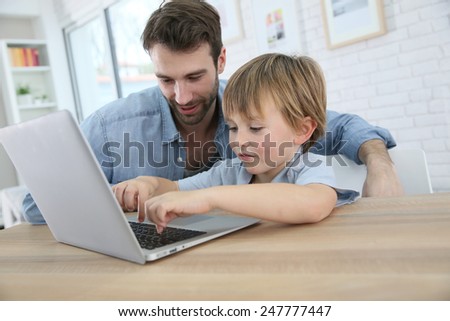 Daddy and son playing on laptop computer