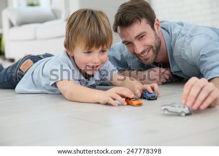 Daddy with little boy playing with toy cars