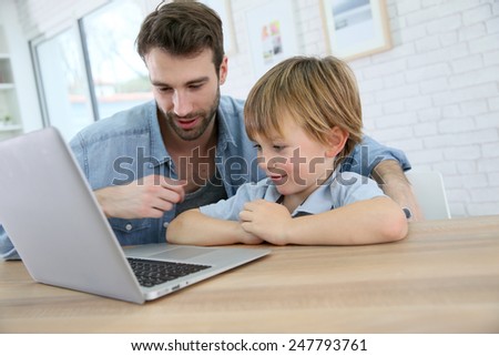 Daddy and son playing on laptop computer
