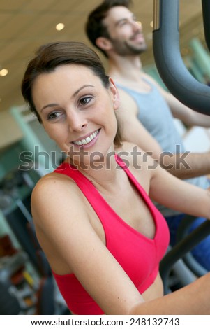 Woman in fitness club using cardio equipment