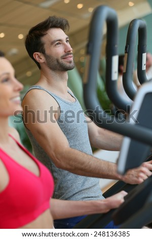 Couple doing cardio training program in fitness center