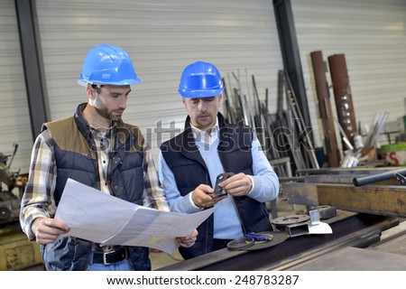 Engineer with mechanical worker checking on production
