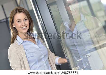 Smiling businesswoman opening office door