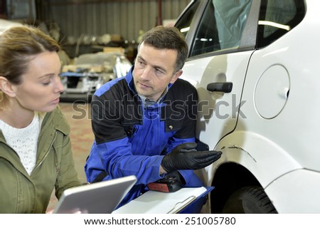 Mechanician with insurance adjuster checking on auto repair