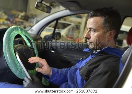 Mechanic doing technical inspection on vehicle